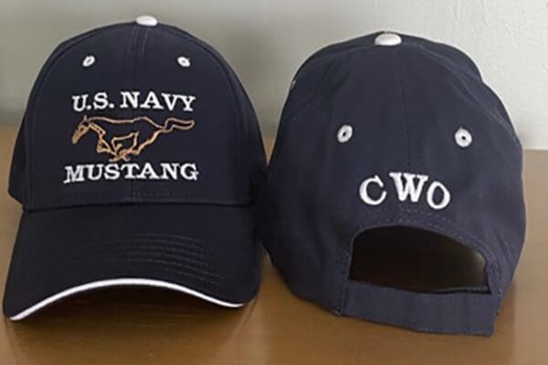 Two navy hats sitting on top of a table.