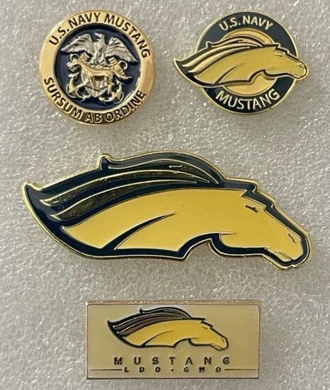 A group of four pins with the u. S. Military and university of southern california logos on them