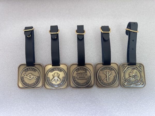 A set of six square brass luggage tags.