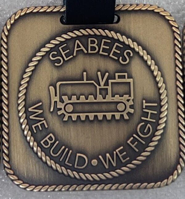 A medal with the words " seabees we build, we fight ".