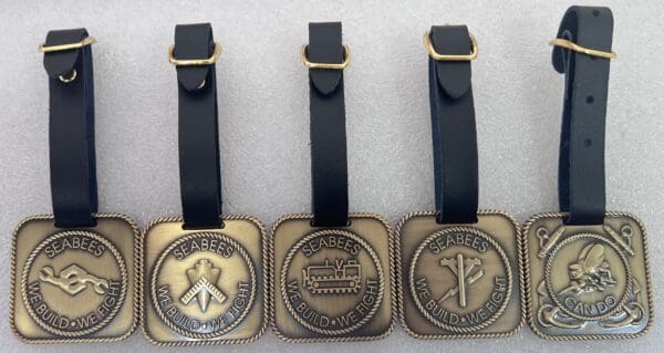 Three different metal tags with a black strap.