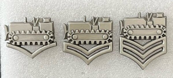 A set of three metal pins with different designs.